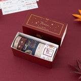 An opened box of Tsuki Torii washi tape set by notebook therapy laid out on red background