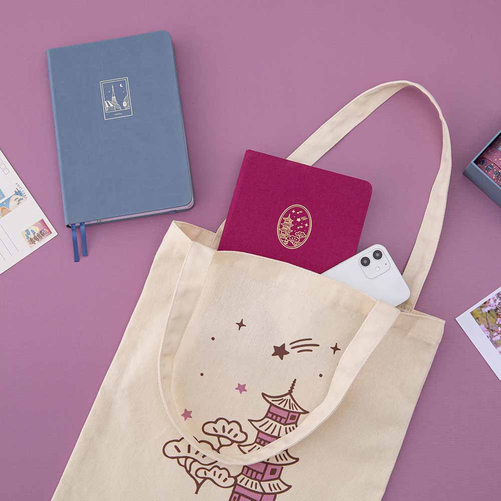 Kyoto notebook and iPhone peeking out of a Kyoto tote bag