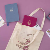 Kyoto notebook and iPhone peeking out of a Kyoto tote bag