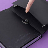 Close up of open back page pocket of Tsuki ‘Moonlit Spell’ Limited Edition Holographic Bullet Journal black paper edition with free bookmark gift held in hand on purple background