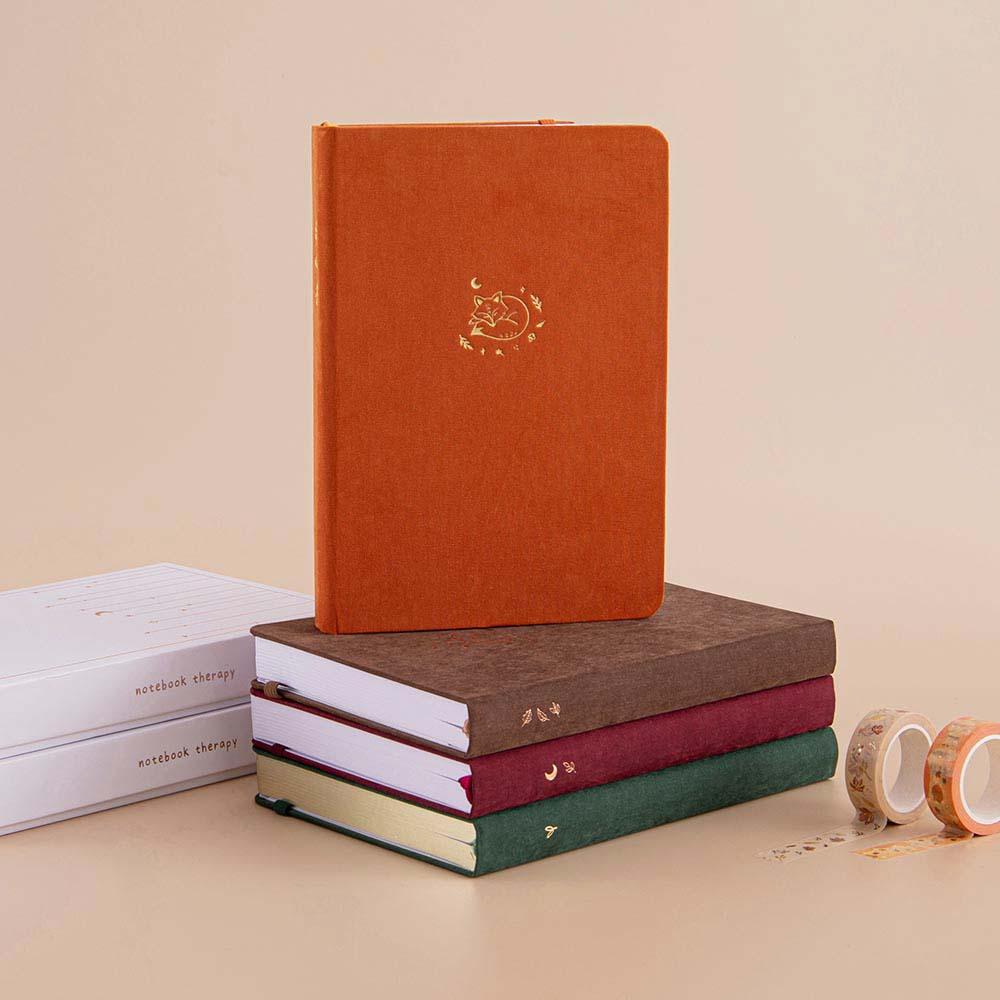 Tsuki ‘Kitsune’ Limited Edition Fox Bullet Journal with Tsuki ‘Midnight Garden’ Limited Edition bujo and Tsuki ‘Kinoko’ Limited Edition notebook and Tsuki ‘Nara’ Limited Edition Bullet Journal with eco-friendly gift boxes with Tsuki ‘Maple Dreams’ Washi Tapes on beige background