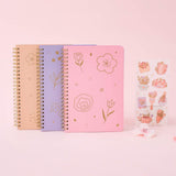 Tsuki floral ringbound notebooks in sakura pink, lilac taro and honey peach with free sticker sheet on pink background