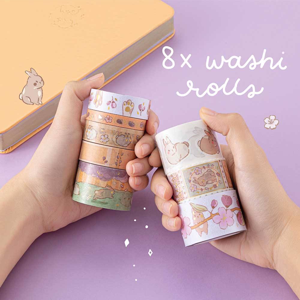 Tsuki Bunny Blush Washi Tape Set designed with Blossom Bujo held in hands over Tsuki Honey Butter ‘Bunny Blush’ Limited Edition Bullet Journal on lilac background