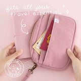 Tsuki ‘Sakura Journey’ Travel Pouch which fits all your travel essentials and Tsuki ‘Sakura Journey’ Limited Edition Travel Journal held in hands in pink background